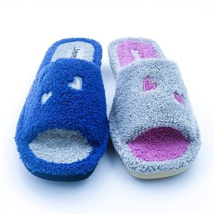 Zapatilla abierta por delante fabricada en toalla y con dibujos de corazones.
